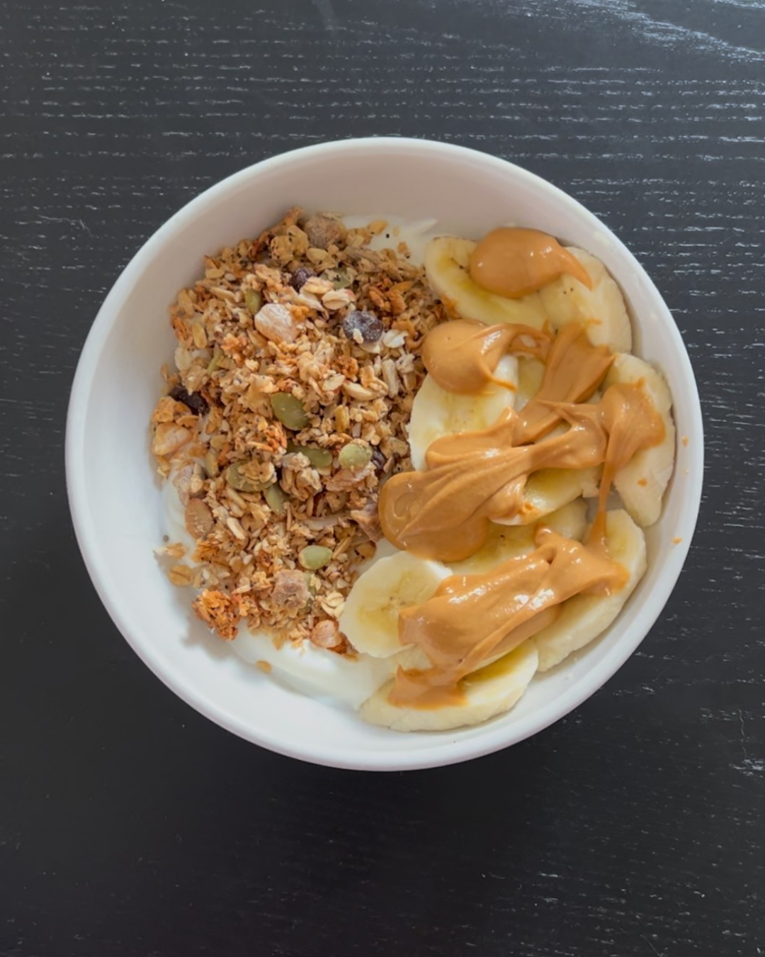 Healthy high-protein granola bowl made with Artisan Granola UK, kefir yoghurt, banana, and peanut butter – balanced breakfast for energy and recovery.