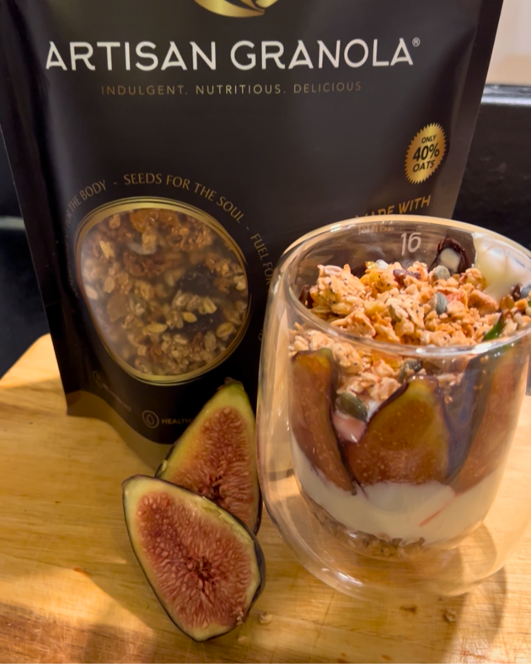 Sticky fig parfait made with creamy yoghurt, fresh figs and crunchy Artisan Granola, displayed next to a branded Artisan Granola pack.