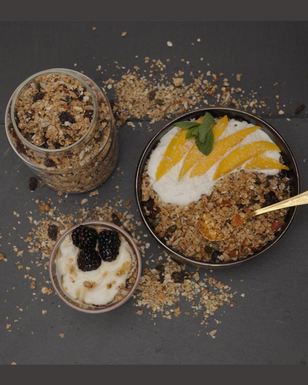 flat lay or Artisan Granola in various bowls with yoghurt, blackberries and mango