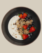 Artisan Granola served with creamy yoghurt, fresh strawberries and blueberries in a black bowl — a healthy, high-fibre breakfast made with natural, handmade granola. 